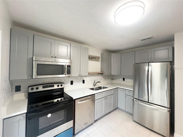 kitchen featuring gray cabinets, sink, light tile patterned flooring, and stainless steel appliances