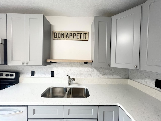 kitchen with gray cabinetry, electric range, sink, and a textured ceiling