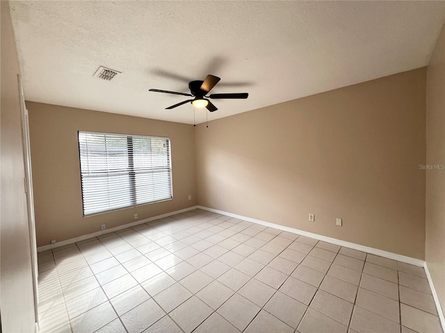 tiled spare room with ceiling fan and a textured ceiling