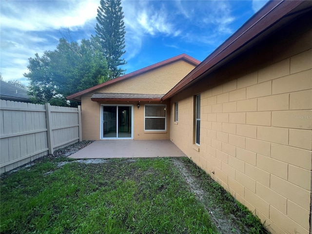 rear view of house featuring a patio area and a lawn