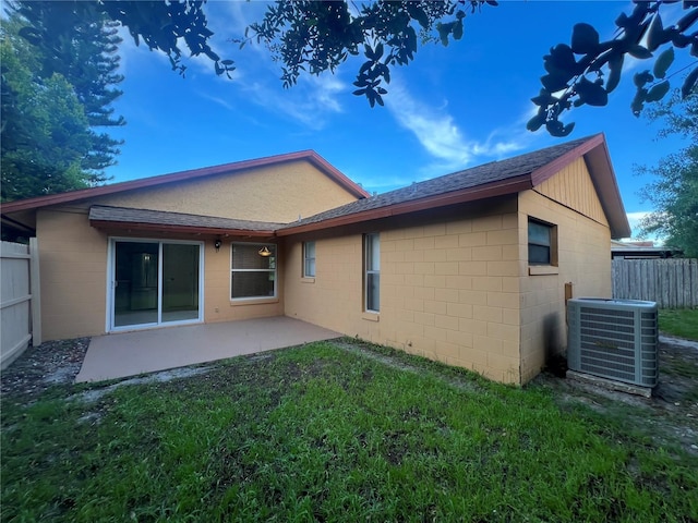 back of property with a yard, a patio, and central AC unit