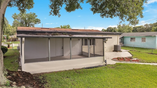 back of house with a yard, central AC, and a sunroom