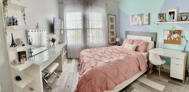 bedroom with multiple windows and light hardwood / wood-style floors