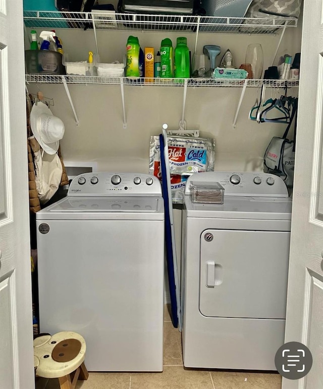 washroom with light tile patterned floors and washing machine and dryer