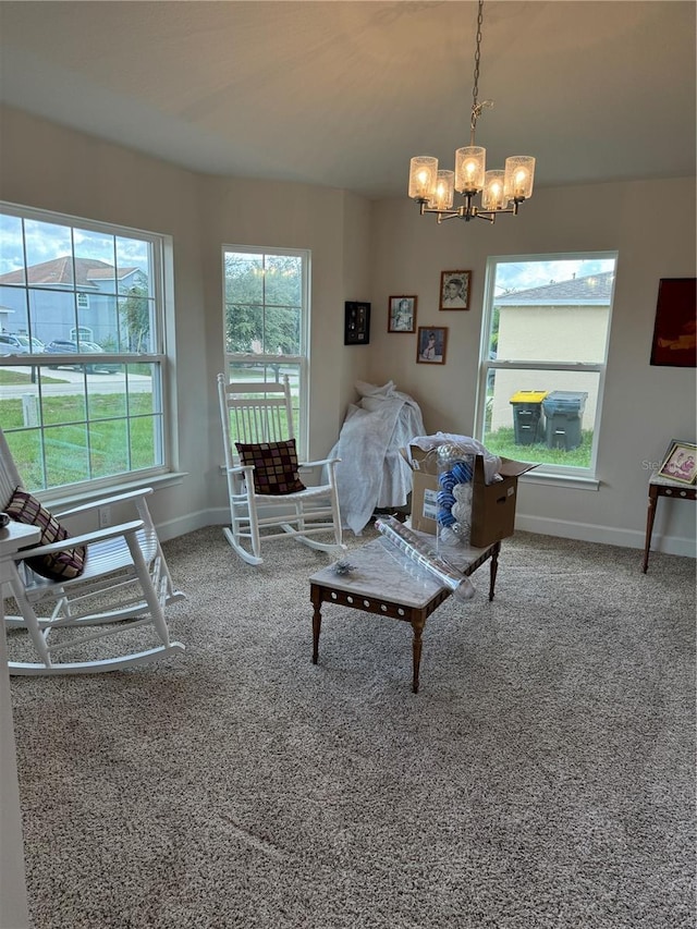 carpeted living room featuring an inviting chandelier