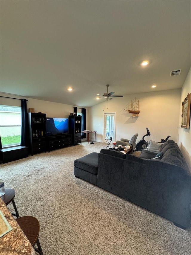 carpeted living room with vaulted ceiling, a healthy amount of sunlight, and ceiling fan