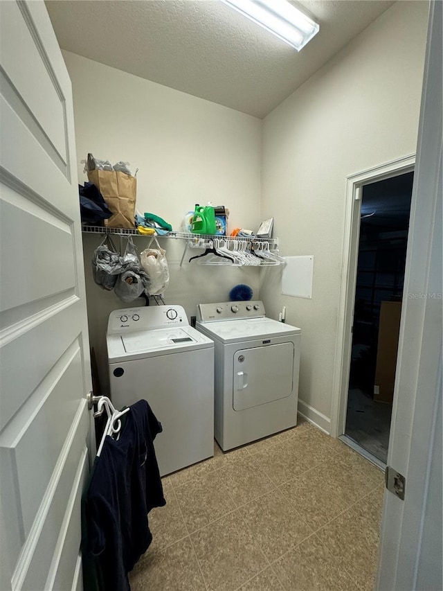 laundry room with washer and dryer and a textured ceiling