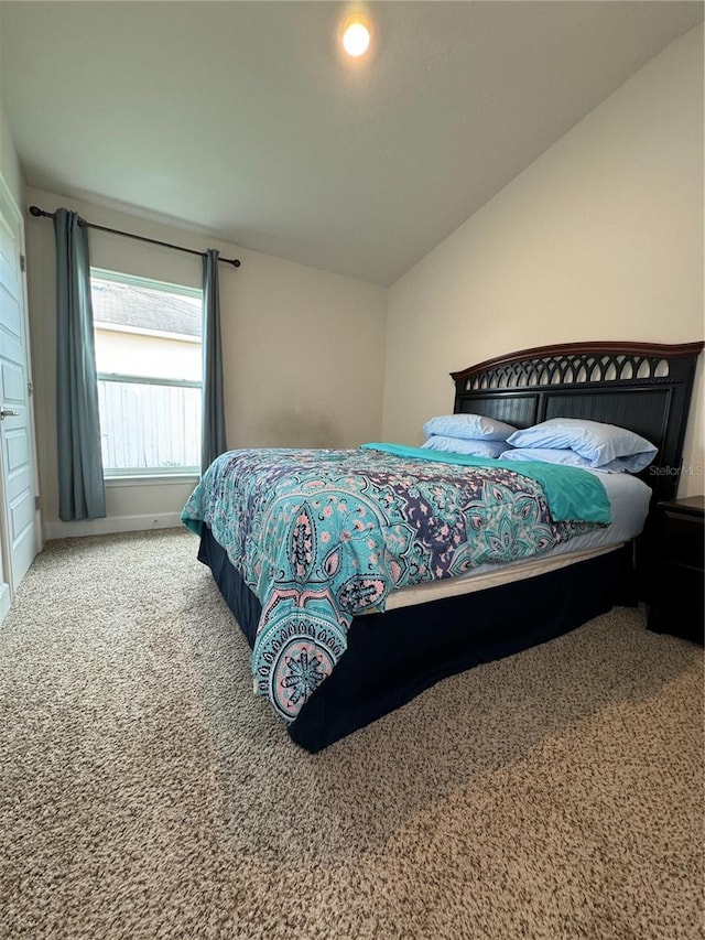 bedroom featuring vaulted ceiling and carpet flooring