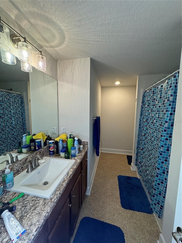 bathroom with vanity, a textured ceiling, and walk in shower