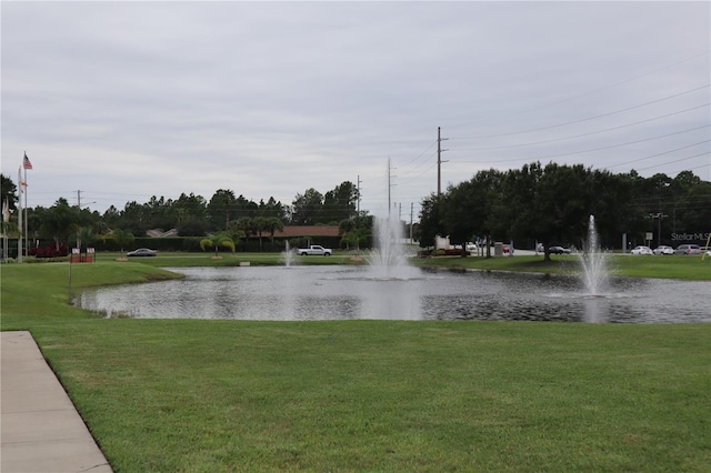 view of community featuring a water view and a yard