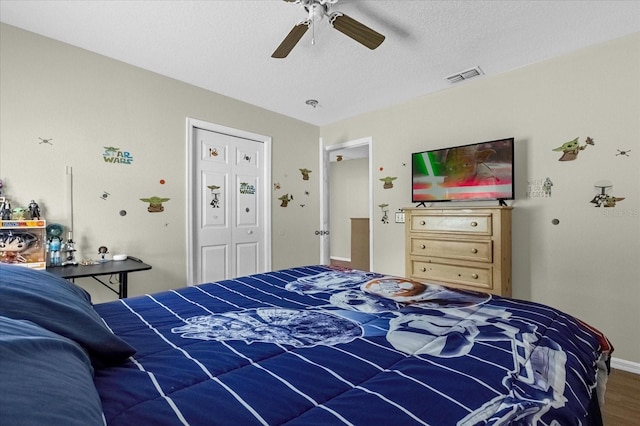 bedroom with ceiling fan, a closet, hardwood / wood-style floors, and a textured ceiling