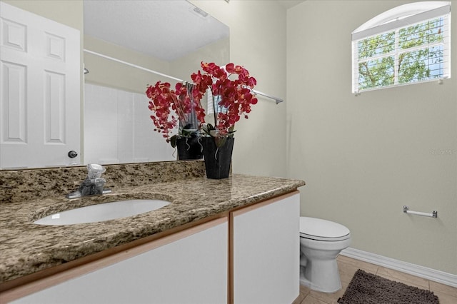 bathroom featuring walk in shower, tile patterned flooring, vanity, and toilet