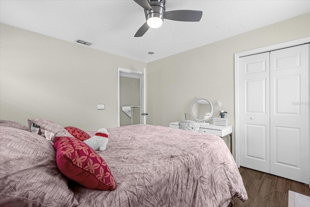 bedroom featuring ceiling fan, dark hardwood / wood-style floors, and a closet