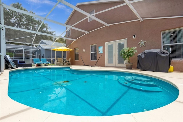 view of swimming pool featuring a lanai, grilling area, a patio area, and french doors