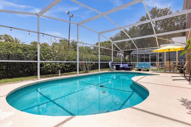 view of swimming pool featuring a lanai and a patio area