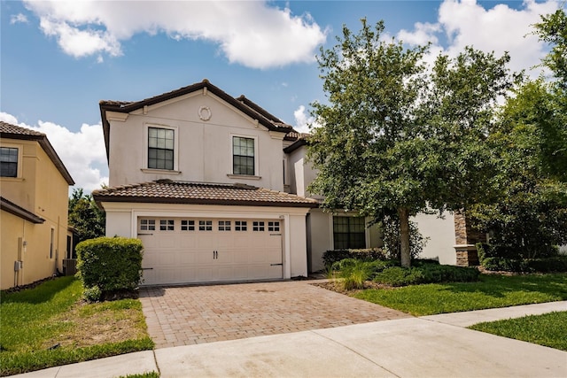 mediterranean / spanish home featuring cooling unit, a front lawn, and a garage