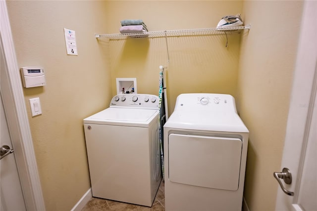 laundry room with washing machine and dryer and light tile patterned floors