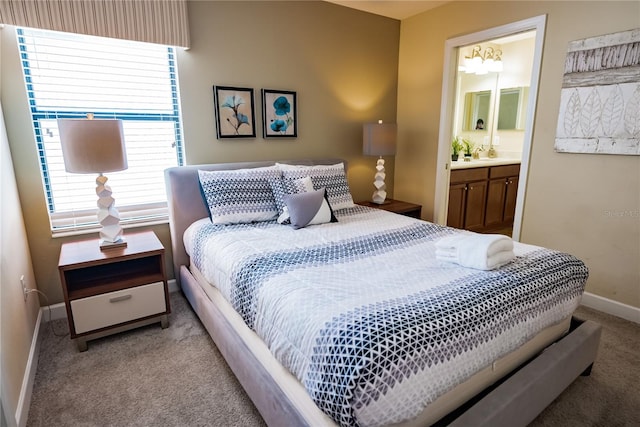 bedroom with ensuite bath and light carpet