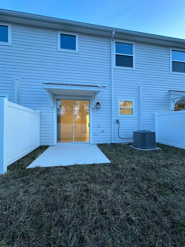 rear view of house featuring a yard, a patio, and central air condition unit