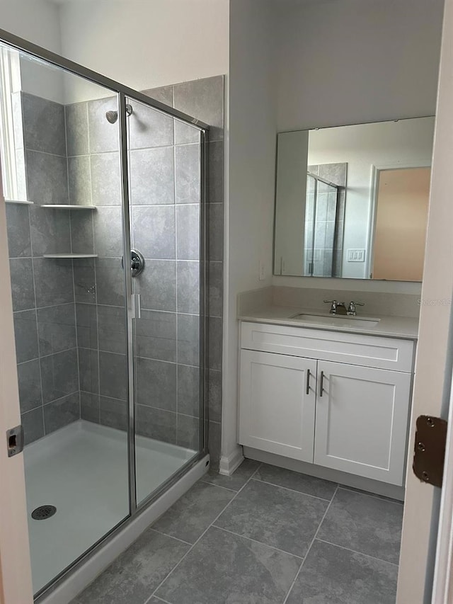 bathroom featuring vanity, tile patterned floors, and a shower with shower door