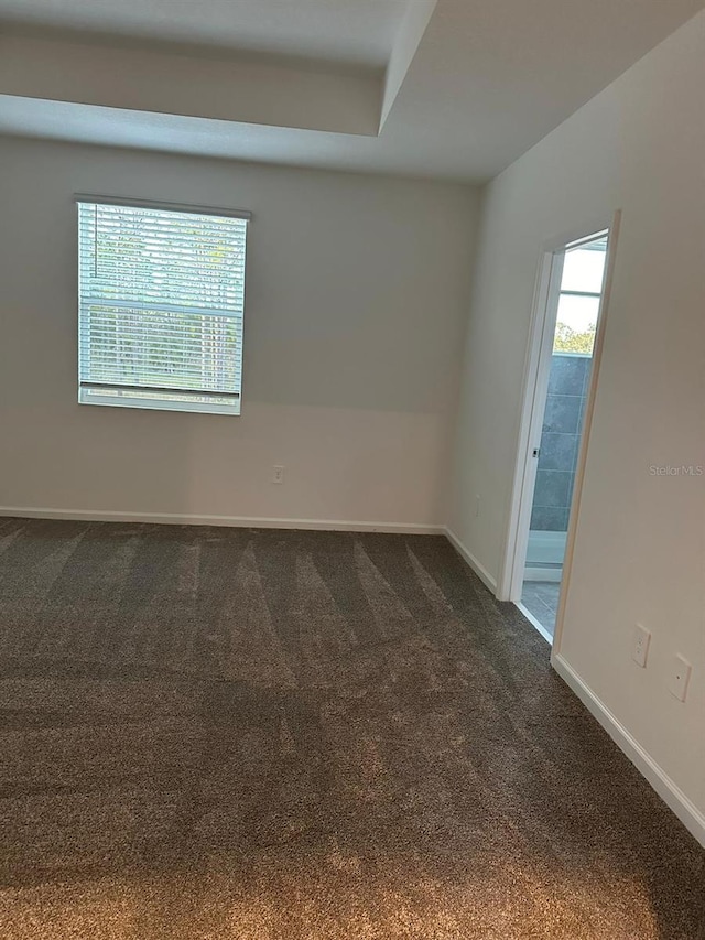 unfurnished room with dark colored carpet