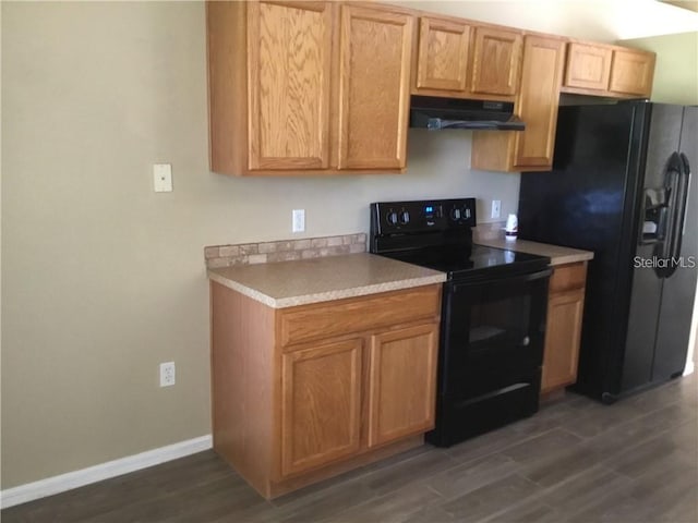 kitchen featuring dark wood-type flooring and black appliances