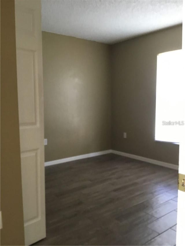 spare room with dark hardwood / wood-style flooring