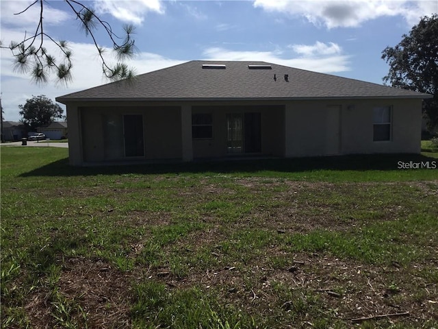 rear view of house with a yard