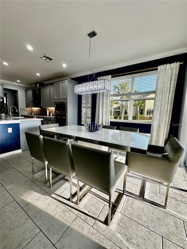 kitchen with gray cabinets, stainless steel microwave, black oven, decorative backsplash, and hanging light fixtures