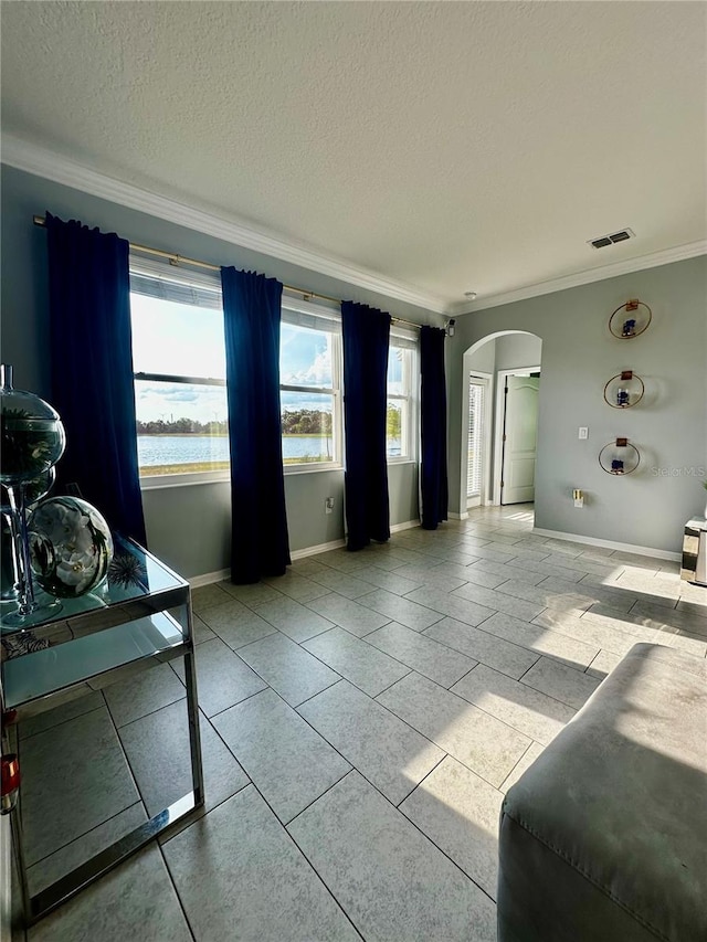 living room featuring crown molding, a textured ceiling, and a water view