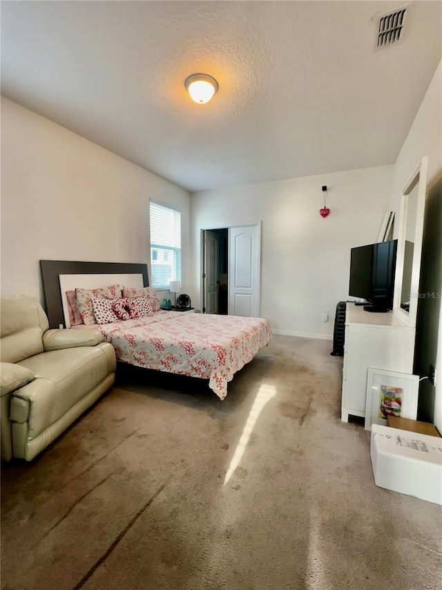 carpeted bedroom featuring a textured ceiling