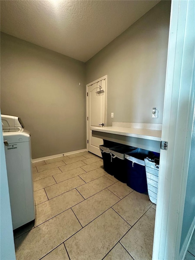 laundry area with washer / clothes dryer and a textured ceiling