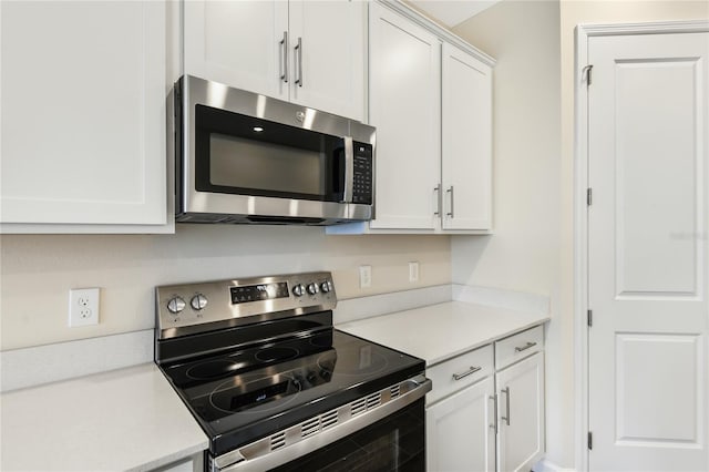 kitchen with white cabinets and appliances with stainless steel finishes