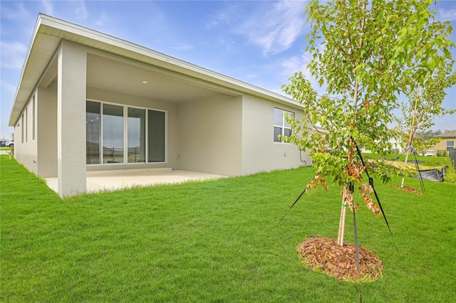 back of property with a patio area and a yard