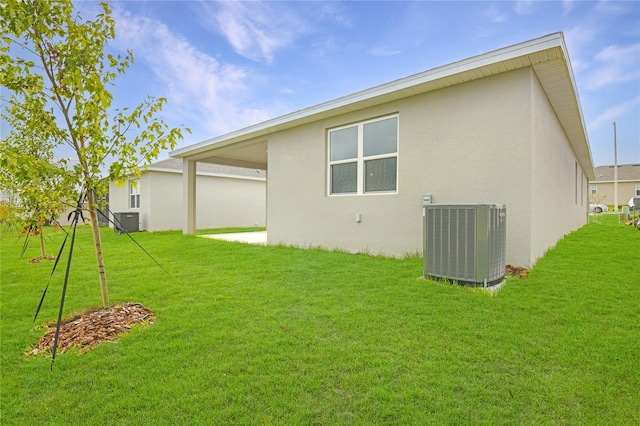 rear view of house featuring cooling unit and a yard