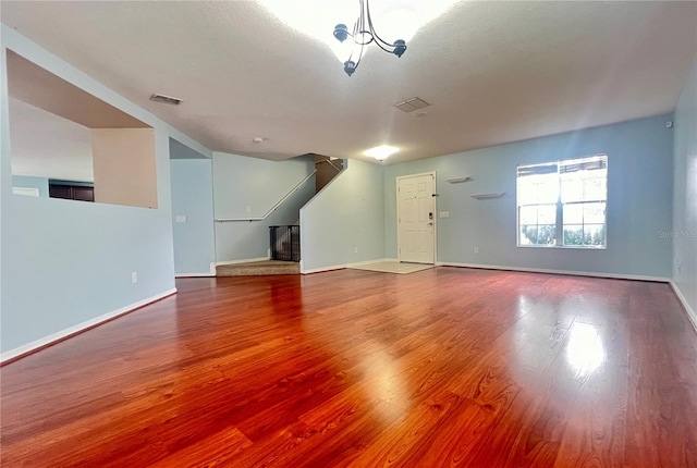 unfurnished living room featuring hardwood / wood-style flooring and a notable chandelier