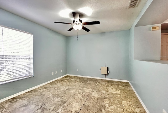 empty room featuring a textured ceiling and ceiling fan