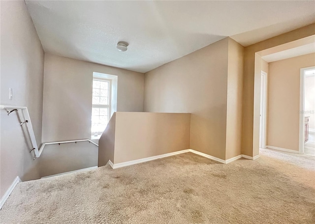 carpeted empty room featuring a textured ceiling