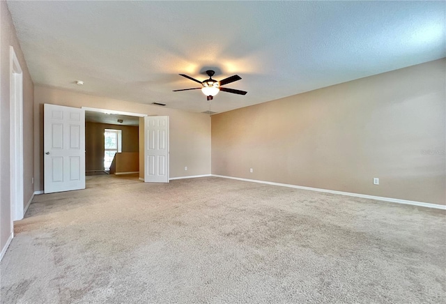 carpeted empty room with ceiling fan and a textured ceiling