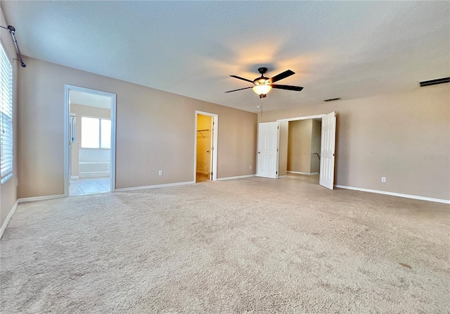 spare room with ceiling fan, light colored carpet, and a textured ceiling