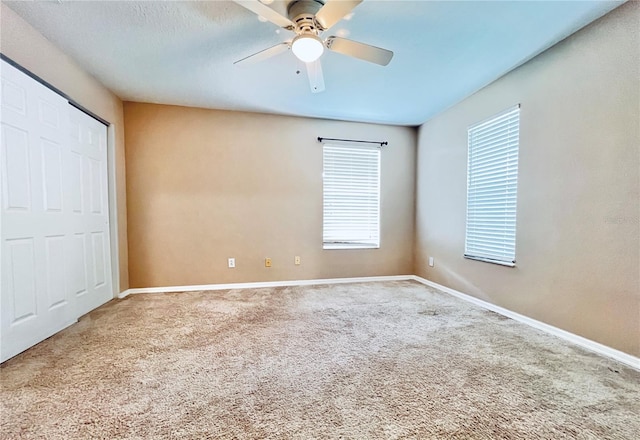 unfurnished bedroom with multiple windows, carpet floors, and ceiling fan