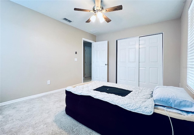 carpeted bedroom with ceiling fan and a closet