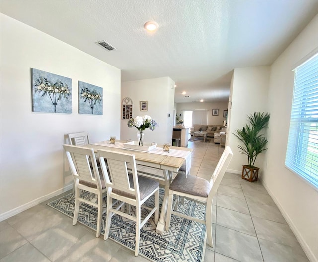 tiled dining area with a healthy amount of sunlight and a textured ceiling