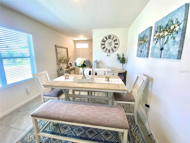 dining room with light tile patterned floors and a textured ceiling