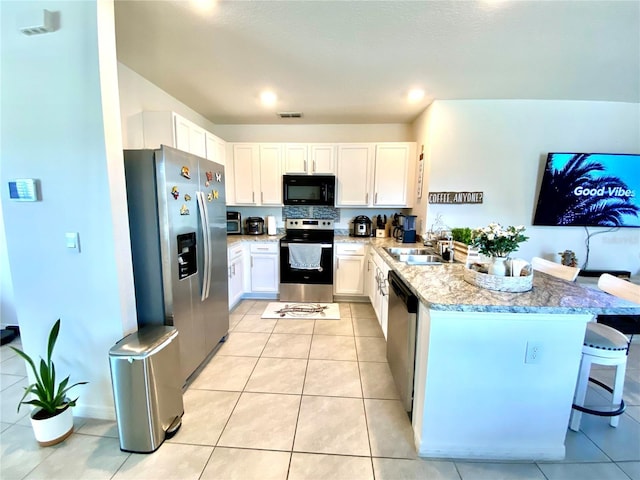 kitchen with kitchen peninsula, a kitchen breakfast bar, stainless steel appliances, sink, and white cabinets