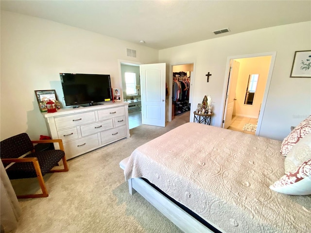 carpeted bedroom featuring connected bathroom, a spacious closet, and a closet