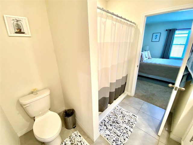 bathroom with tile patterned flooring, a shower with shower curtain, and toilet