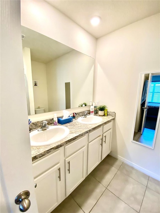 bathroom with tile patterned flooring, vanity, and toilet