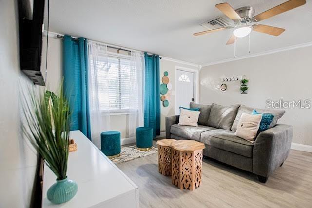 living room featuring ceiling fan, light hardwood / wood-style floors, and crown molding