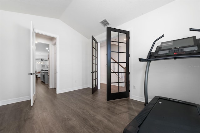 workout area with dark hardwood / wood-style floors, french doors, and vaulted ceiling